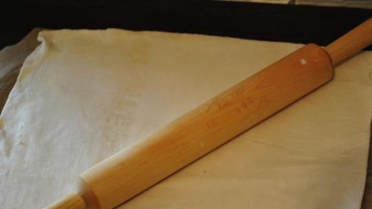 1. Этап. Косичка с шоколадом из слоеного теста: Раскатываем размороженное слоеное тесто в прямоугольник. Размер — раза в три больше, чем плитка шоколада. Выкладываем раскатанное тесто на лист пергамента.