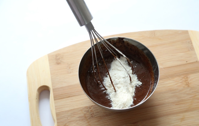 1. Этап. Вкуснейший шоколадный фондан: 3. Добавляю к шоколадно-яичной массе пшеничную муку и перемешиваю венчиком до образования однородной консистенции.