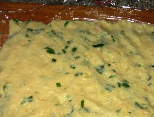 1. Этап. Мясной рулет в картофельной оболочке: В готовое картофельное пюре добавляем одно яйцо, немного крахмала, 50 граммов сыра и мелко порубленную зелень. Все перемешиваем и укладываем ровным пластом на пищевую пленку. Толщина такого слоя - примерно 1,5 см.