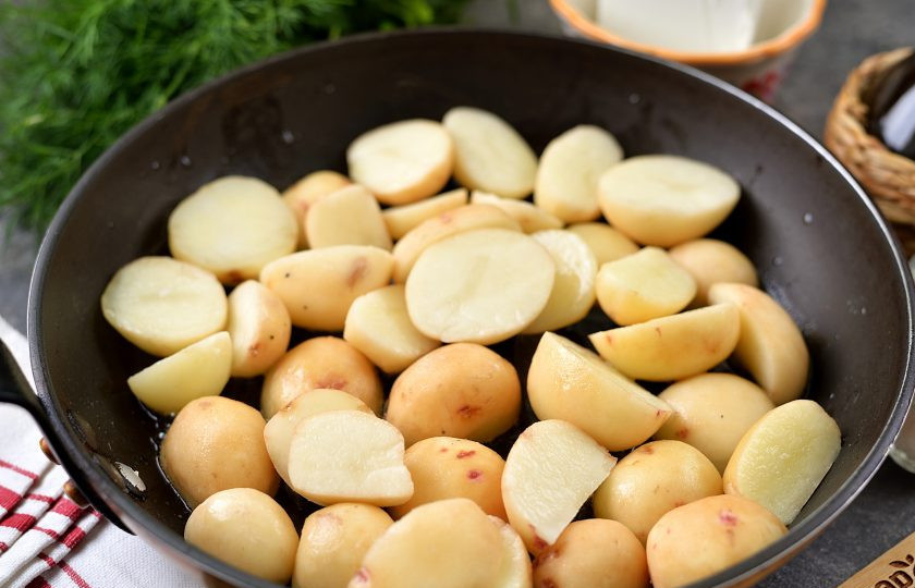 1. Этап. Картофель по-деревенски с фетой и красным луком: Разогрейте в сковороде растительное масло, выложите в него разрезанный пополам молодой картофель, жарьте на умеренном огне минут 15.