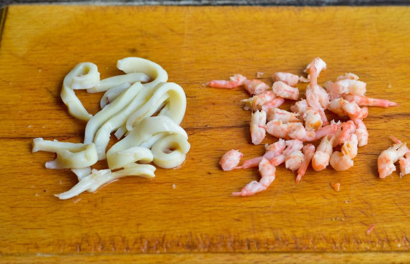 1. Этап. Салат с кальмарами, креветками и ананасами: Нарежьте кальмар соломкой, креветки очистите и тоже нарежьте.