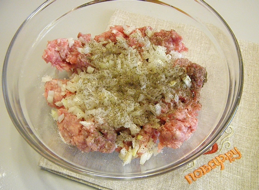 1. Этап. Пельмени с сыром в духовке: Приготовьте начинку. В фарш добавьте мелко порезанный репчатый лук, соль, перец черный молотый. Тщательно перемешайте.