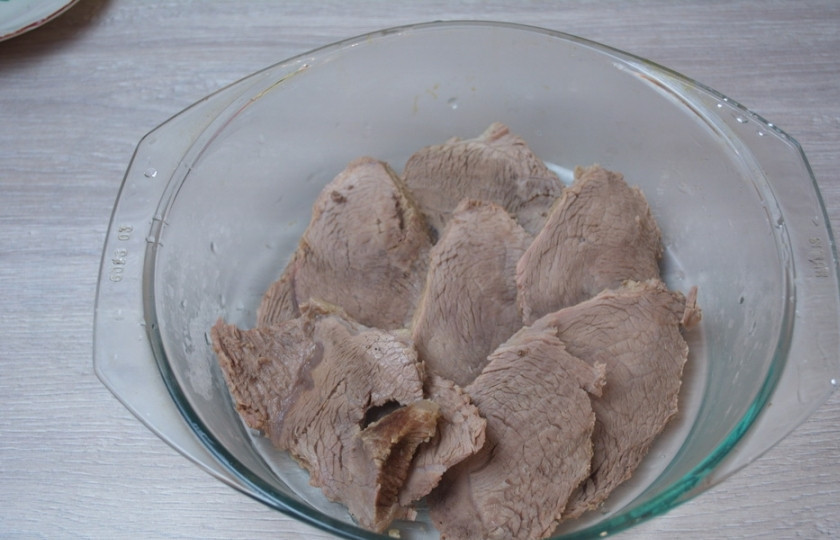 1. Этап. Мясо под соусом сметанным: Форму для запекания смажьте маслом. Уложите в нее мясо. Залейте сметанным соусом.