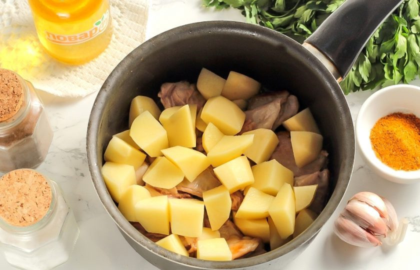 1. Этап. Баранина с картофелем и грибами: Нарежьте очищенный картофель средними кубиками и добавьте в емкость. Обжарьте вместе с мясом еще 4-5 минут.