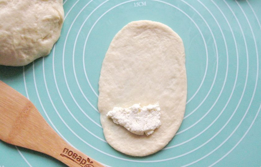 1. Этап. Булочки Как у бабушки: Я сделала два вида булочек. Тесто разделите условно на две части. Одну часть разделите на шарики. Каждый шарик раскатайте в продолговатую лепешку. В творог добавьте сахар по вкусу и перемешайте. Начинка для булочек готова. На край лепешки выложите чайную ложку творога.