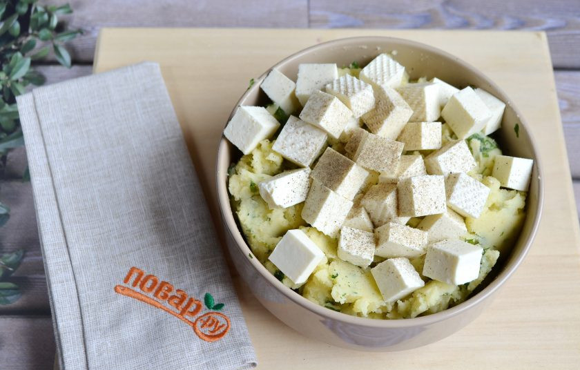 1. Этап. Деревенский картофельный пирог: 7. Добавьте брынзу, порезанную кубиками крупными, перец черный молотый, перемешайте.