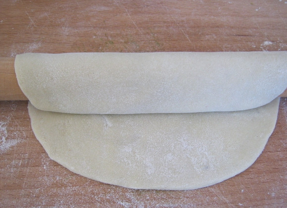 1. Этап. Турецкие лепешки гезлеме: 2. Готовое тесто разделяем на 3 шарика, каждый раскатываем скалкой в круг диаметром 17-20 сантиметров. После чего наматываем тесто на скалку и раскатываем от середины до краев. В результате получаем круг, размером около 30 сантиметров.