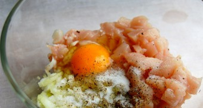 1. Этап. Котлеты рубленые: Куриное филе нарезать, порубить на мелкие кусочки. Чтобы мясо было легко резать, подержите его в морозилке минут 20. Теперь большим ножом (острой частью) начинаем отбивать кусочки куриного мяса (берём несколько кусков и простукиваем их ножом, периодически переворачивая). Наша цель не разрезать куски, а разбить волокна мяса до «липкого» состояния. Мясо перекладываем в миску, куда отправляем яйцо, мелко рубленный лук, не забываем также посолить и поперчить.