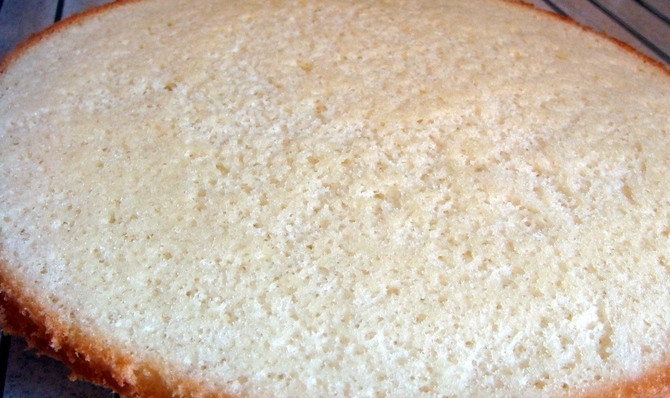 1. Этап. Творожно-йогуртовый торт: Яйца разбиваем в глубокую миску и взбиваем их до образования густой пены. Добавляем 4 ложки сахара и продолжаем взбивать, пока сахар полностью не растворится. Теперь всыпаем просеянную муку и аккуратно лопаткой вмешиваем ее складывающими движениями. Форму для запекания диаметром 23-24 см накрываем пергаментом и выкладываем в нее приготовленную смесь, выравниваем. Ставим в разогретую до 180 градусов духовку и выпекаем 15 минут. Затем достаем бисквит и ждем, пока он полностью остынет.