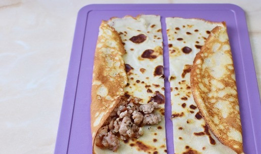 1. Этап. Блины-треугольники с фаршем: Блин разрежьте напополам. Выложите немного начинки и подверните край.