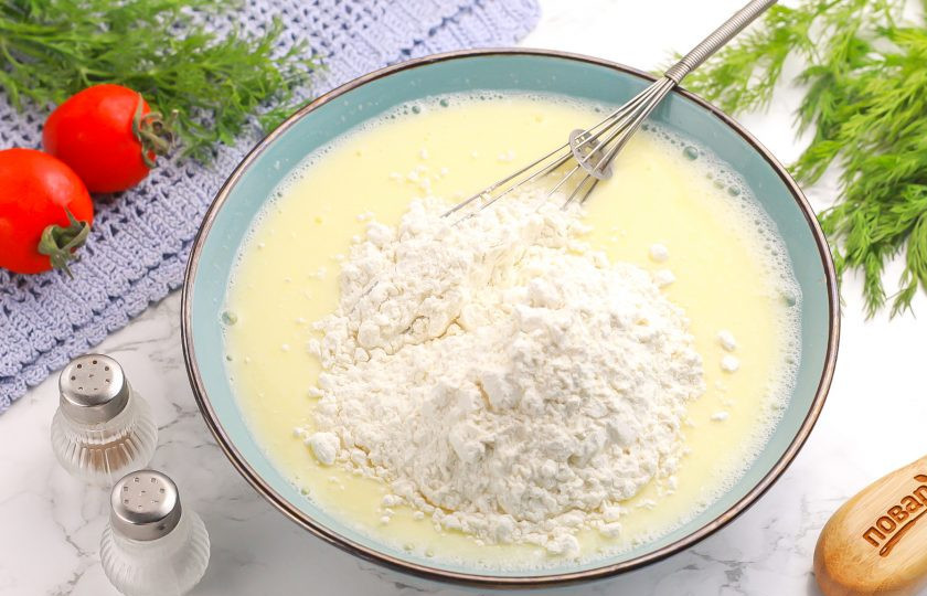 1. Этап. Блины с начинкой из баклажанов: Влейте кипяток и сразу же перемешайте. Всыпьте пшеничную муку высшего сорта и аккуратно вмешайте ее в жидкую основу. Последним влейте растительное масло и еще раз перемешайте.