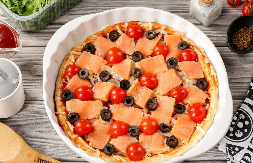 1. Этап. Пицца с рыбой: Затем распределите хаотично нарезанные маслины и помидоры черри, разрезанные на 2-3 части.