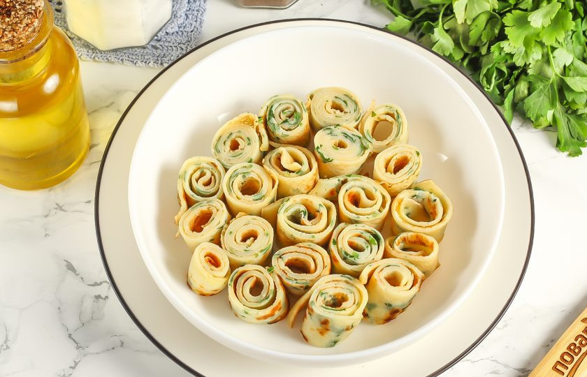 1. Этап. Фриттатензуппе: Сверните блинчики рулетиком и нарежьте их на части толщиной 1-2 см. Выложите нарезку в глубокую тарелку.