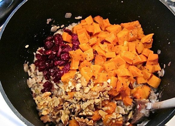 1. Этап. Салат с рисом: 5. Мускатную тыкву нарезаю кубиками и добавляю в казан, туда же отправляю сушеную клюкву и грецкие орехи.