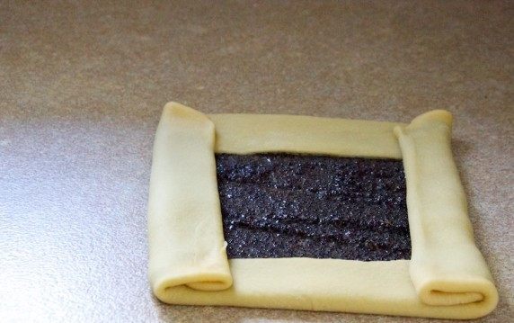 1. Этап. Маковый штрудель: 3. Каждую часть теста раскатайте в тонкий овальный пласт, выложите начинку, оставляя по 1-2 см от края. Подверните по 1 разу со всех сторон, а затем 2 противоположные стороны подверните еще 1 раз.