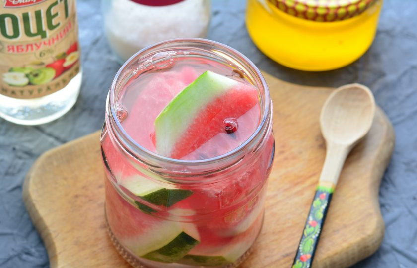 1. Этап. Арбузы маринованные с медом: Влейте кипяток в банки с арбузом и оставьте на 15 минут.