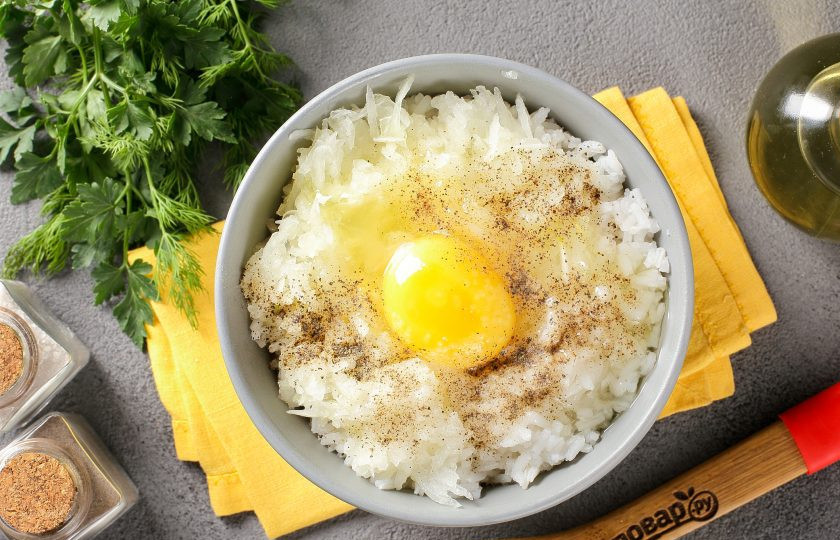 1. Этап. Тефтели из судака: Добавьте рис, тёртый на крупной тёрке лук, яйцо, соль и специи по вкусу.