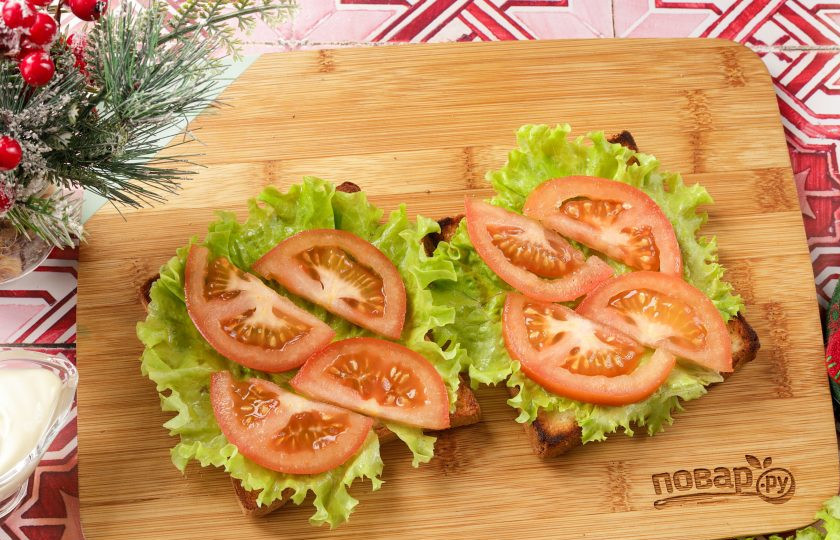 1. Этап. Бутерброды Змейка для праздничного стола: Сверху выложите нарезанный дольками или кружками помидор. По желанию помидоры можете посолить и поперчить по вкусу.