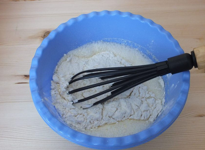 1. Этап. Пасхальные куличи на разрыхлителе: Добавьте в желтковую массу горячее молоко, мягкое масло и размешайте. Муку смешайте с разрыхлителем и добавьте к массе.