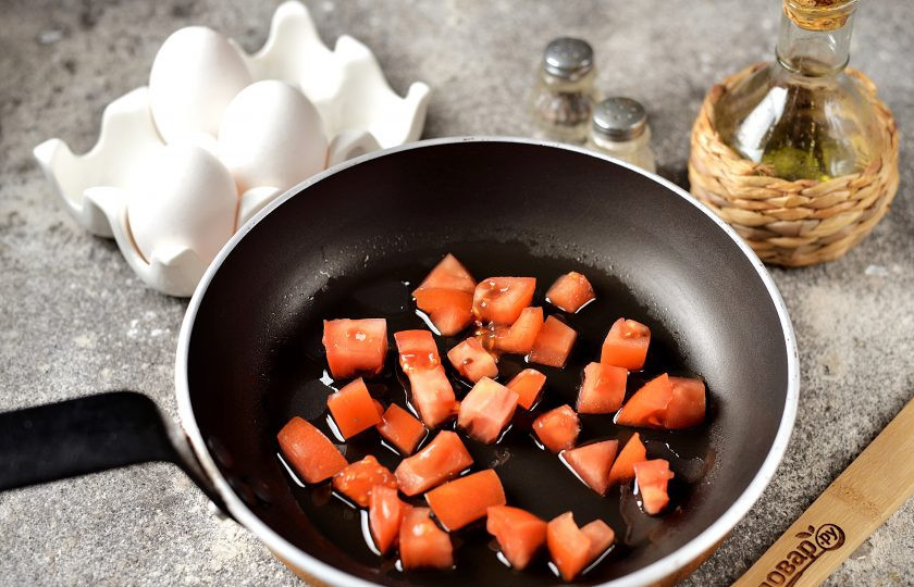 1. Этап. Яичница со шпинатом и помидорами: Помидор помойте, удалите место плодоножки. Нарежьте мякоть мелким кубиком, переложите в сковороду, влейте растительное масло. Обжарьте помидор на умеренном огне около минуты.