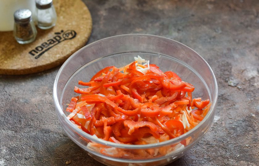 1. Этап. Салат из маринованной капусты с морковью: Нарежьте сладкий перец небольшими полосками и переложите в салат. По желанию добавьте немного масла.