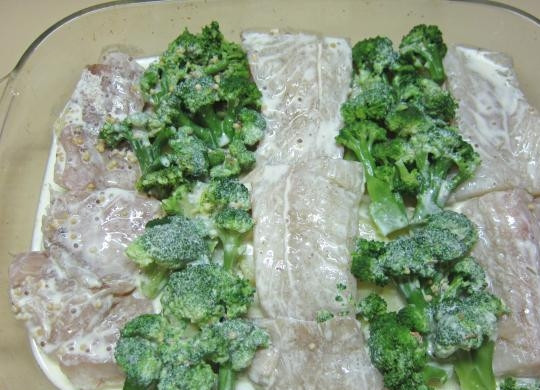 1. Этап. Треска с брокколи в духовке: Поставьте разогреваться духовку до 180 градусов. В форму для выпечки выложите картофель и рыбу. Потом брокколи, и залейте всё соусом.