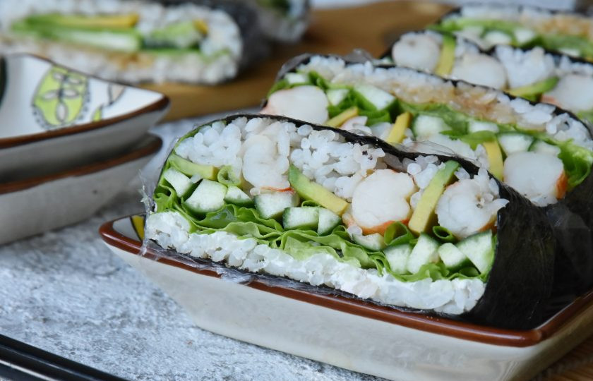 1. Этап. Суши сэндвич с креветкой: Сэндвич разрежьте пополам, не удаляя пищевую пленку. Можно разрезать вдоль или наискосок от угла к углу.