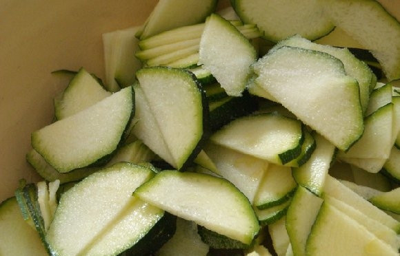 1. Этап. Салат по-корейски из кабачков: Кабачок вымыть и, не снимая кожуры, нарезать тонкой соломкой или ломтиками. Посолить, перемешать и оставить на примерно полчаса (можно небольшим гнетом придавить, чтобы жидкость быстрее выходила).