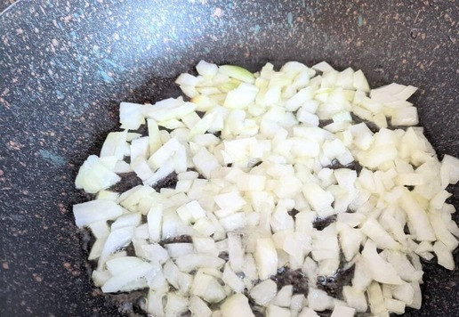 1. Этап. Кальмары, фаршированные рисовой полентой и овощами: Готовим начинку. Лук режем мелкими кубиками. На горячую сковороду наливаем растительное масло, обжариваем лук до мягкости на среднем огне.