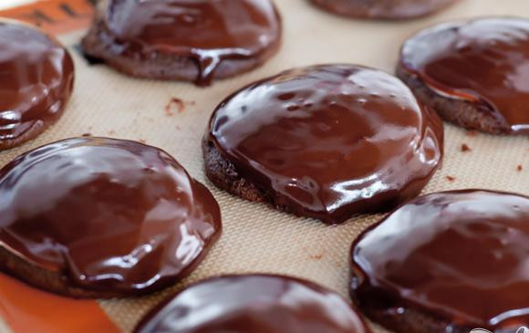 1. Этап. Печенье с зефирной начинкой и шоколадной глазурью: 4. Сделать шоколадную глазурь. Смешать крупно нарезанный шоколад, сливочное масло и кукурузный сироп в миске. Поместить в микроволновую печь на 30 секунд. Перемешать до однородности. Если кусочки шоколада еще остались, поставить в микроволновку еще на 15 секунд. После того, как смесь станет однородной, перемешать с ванильным экстрактом. Охладить до комнатной температуры. Залить шоколадной глазурью печенье поверх зефирной начинки.