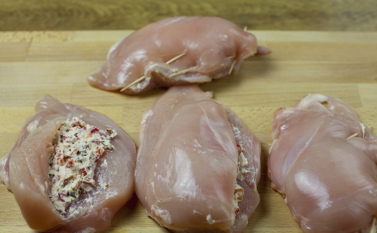 1. Этап. Грудка с фасолью: Теперь делаем кармашек в каждом куске куриной грудки и наполняем их смесью из вяленых помидор, перца и сыра. Скрепляем края зубочистками и втираем в грудки во всех сторон соль и перец.