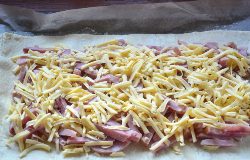 1. Этап. Пирог с начинкой из сыра и ветчины: Затем обильно присыпьте тертым сыром.