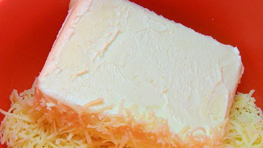 1. Этап. Печенье с сыром: Натираем сыр на терке и добавляем к нему мягкое сливочное масло. Размешиваем.