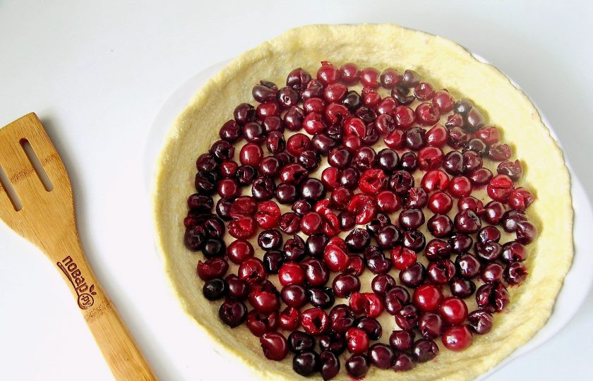 1. Этап. Киш с вишней: Сверху на тесто выложите равномерно всю вишню.