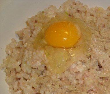 1. Этап. Котлеты из путассу: Отожмите булочку или хлеб от воды и положите к фаршу. Добавьте в него соль, перец, сахар. Также вбейте куриные яйца. Все тщательно перемешайте.