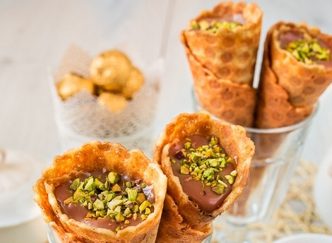 1. Этап. Вафельные трубочки с кремом: Из горячих вафель скрутите конусы. Остудите их, а потом наполните кремом и украсьте по желанию. Приятной дегустации!