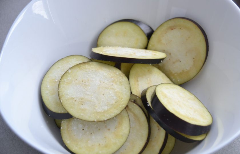 1. Этап. Итальянский салат Пармиджано: Баклажан нарежьте тонкими ломтиками, посыпьте крупной морской солью, оставьте на 5-7 минут.