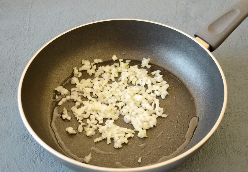 1. Этап. Вареники с тофу: Разогрейте сковороду на среднем огне. Обжарьте мелко нарезанный лук до золотистого цвета.