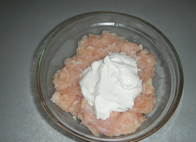 1. Этап. Картофель, запеченный с фаршем: В фарш выдавите чеснок, посолите и добавьте сметану.