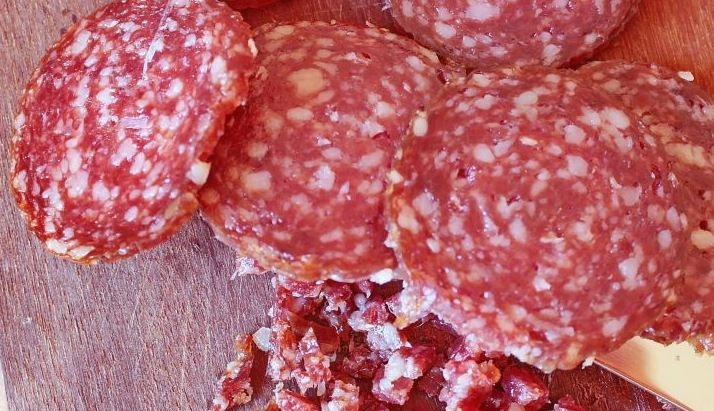 1. Этап. Салат с копченой колбасой и сыром: Слайсы копченой колбаски нарежьте на маленькие кубики.