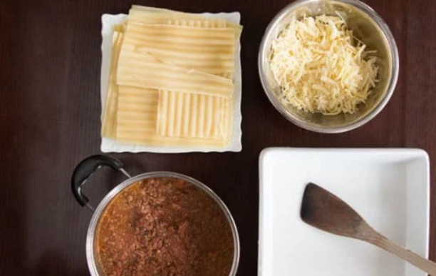 1. Этап. Вкуснейшая лазанья: 6. В подсоленной кипящей воде отварите пасту в течение 5-8 минут. Натрите на терке сыр, снимите соус с огня.