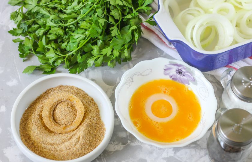 1. Этап. Хрустящий жареный лук: Вбейте куриное яйцо в пиалу, посолите, поперчите и взбейте. Панировочные сухари высыпьте в другую пиалу. Луковые кольца сначала окунайте в яичную массу, затем в массу из сухарей.