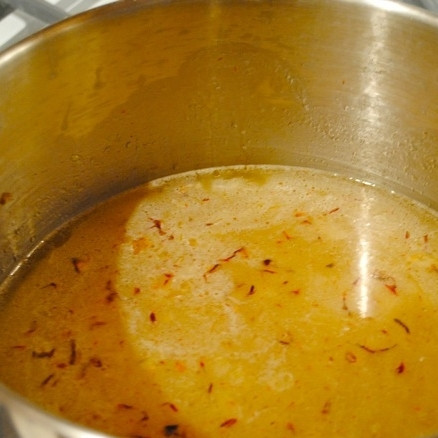 1. Этап. Кускус с миндалем и изюмом: Добавляем бульон и вино, увеличиваем огонь и доводим содержимое кастрюли до кипения.