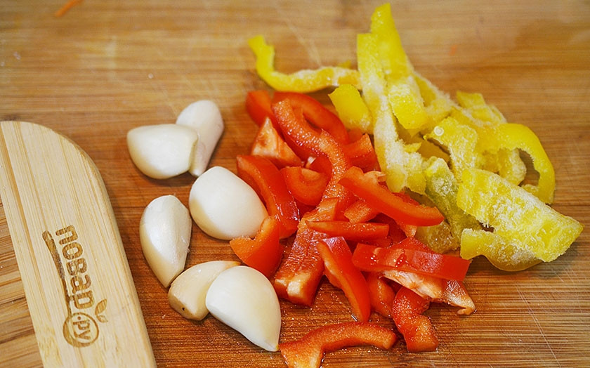 1. Этап. Паэлья с цыпленком и чорризо: 1. Перец нарежьте, чеснок почистите.