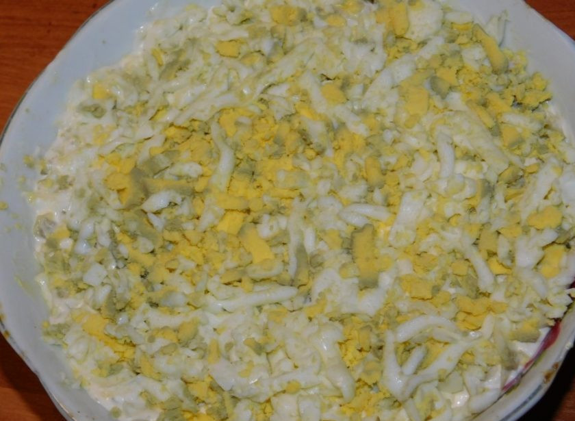 1. Этап. Слоеный салат с черносливом: Затем натрите предварительно отваренные и очищенные яйца. Распределите поверх слоя яблок.