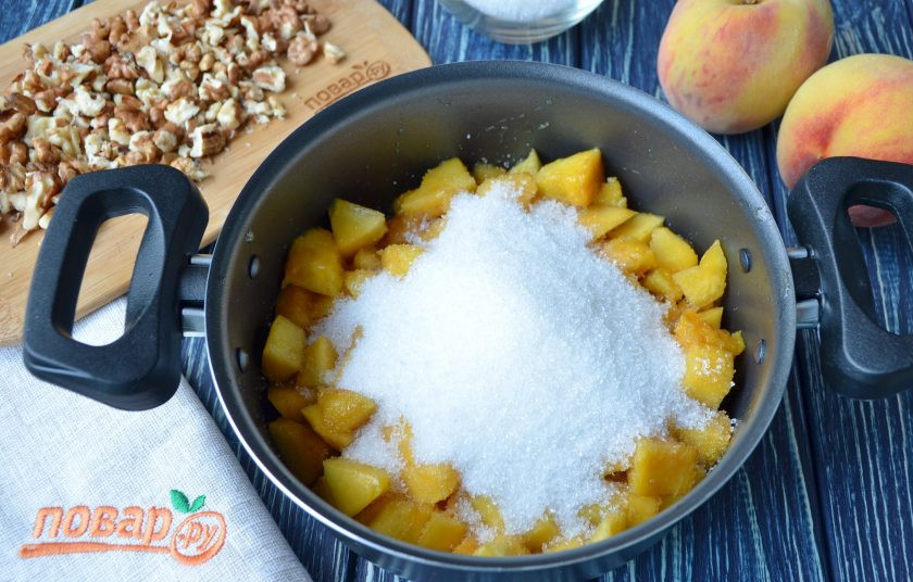 1. Этап. Варенье из персиков с грецкими орехами: Добавьте сахар, перемешайте и оставьте на 1 час, чтобы персики пустили сок.