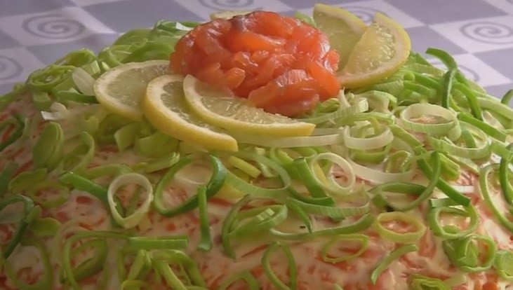 1. Этап. Слоеный салат Королевская шуба: 9. Украсьте салат колечками лука-порея, розой из красной рыбы и ломтиками лимона.