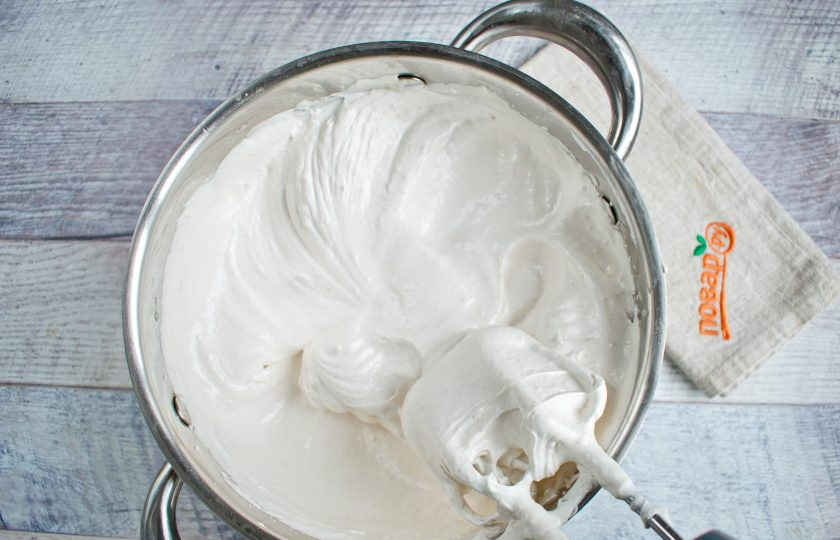 1. Этап. Зефир по ГОСТу: Переложите массу в большую емкость (объем не менее 3 л). Начните взбивать массу на высокой скорости и тонкой струйкой вливайте горячий сироп. Взбивайте в течение 5-7 минут.