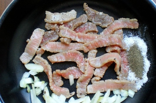 1. Этап. Искандер кебаб: Мясо оставьте на час в маринаде из половины оливкового масла, уксуса и соли. Затем нарежьте его полосками. Обжарьте 5 минут в оставшемся масле вместе с нашинкованным луком, солью и перцем.