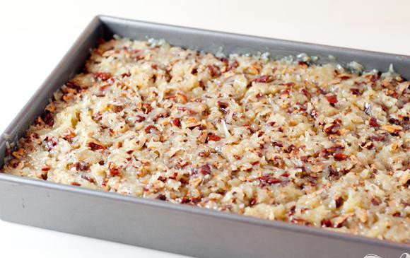 1. Этап. Пирожные с орехами и кокосовой стружкой: 5. Перемешать с нарезанными орехами и кокосовой стружкой. Вылить смесь поверх пирожных.